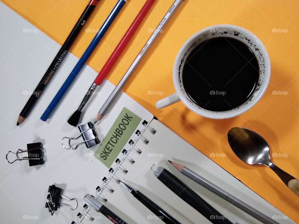 black coffee and pencil drawings equipment on the table