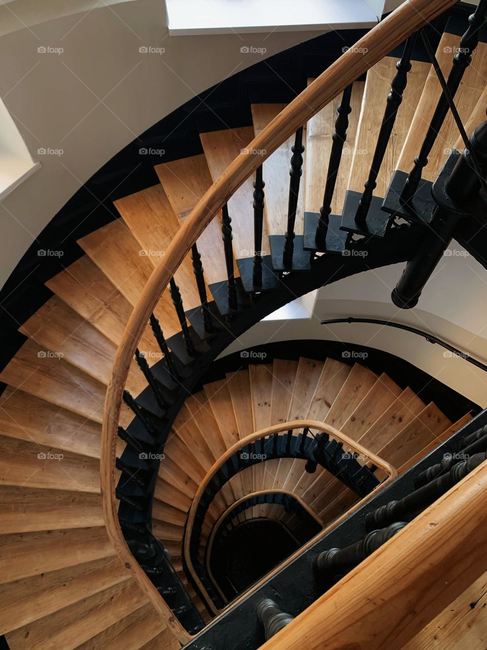Aesthetic old spiral staircase in the old building, wooden stairs, warm light. Photos is taken from above 