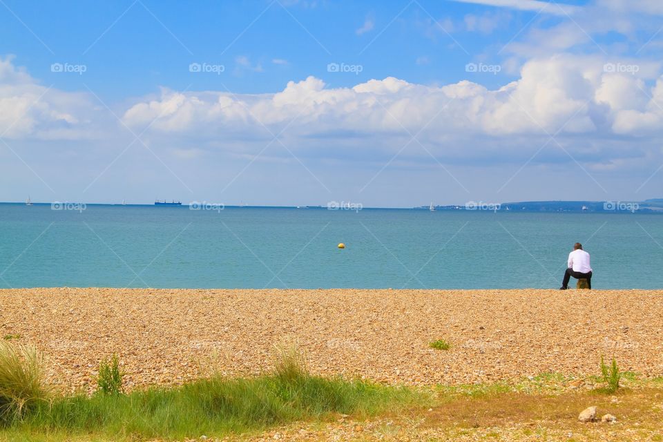 Man sitting on an empty beach