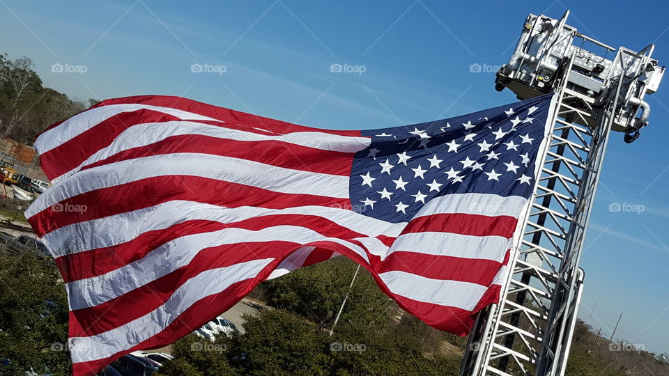 American flag flying from fire engine ladder.