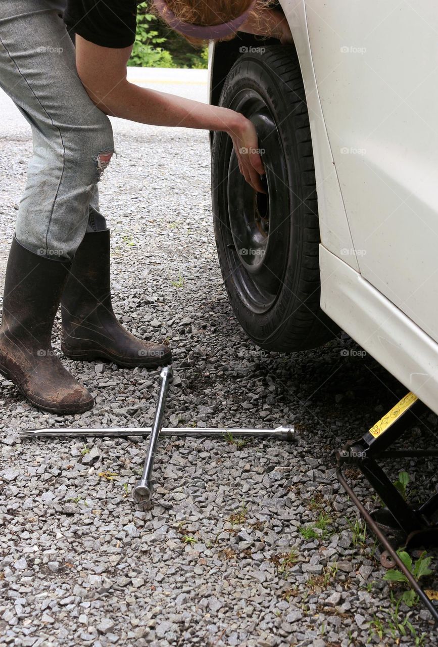 Putting on a spare tire after getting a flat.