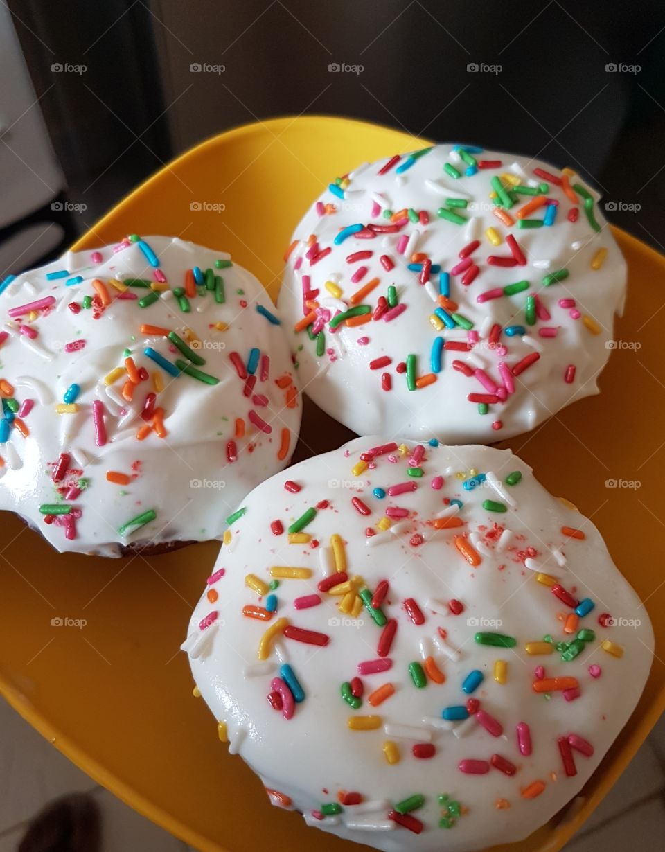 vanilla cupcakes with whipped cream and sprinkles