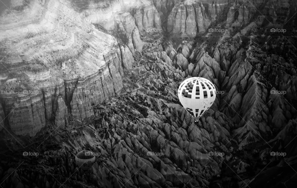 black and white photo of a hot air balloon in top of a valley