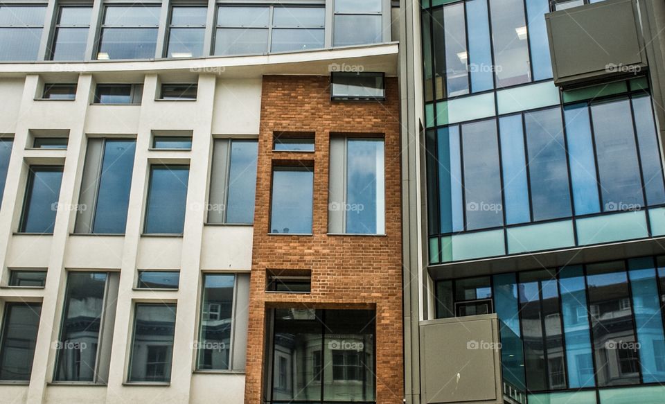 Building fronts in brick, glass and concrete and comprised mostly of rectangles