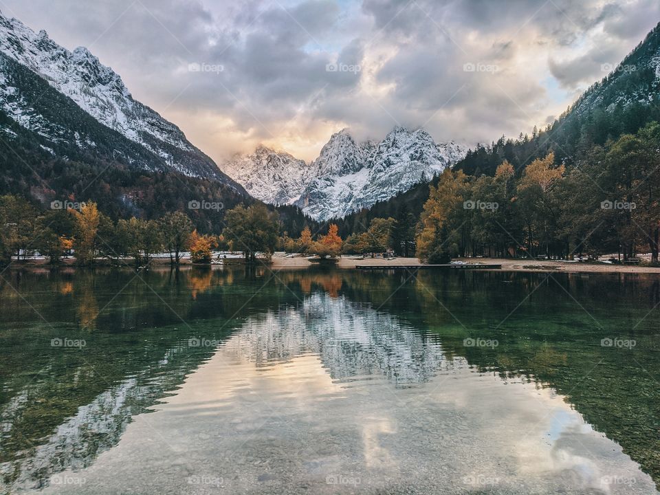Scenic view of the beautiful reflection of the blue cloudy sky and Alps mountains in a lake in autumn trip in Slovenia