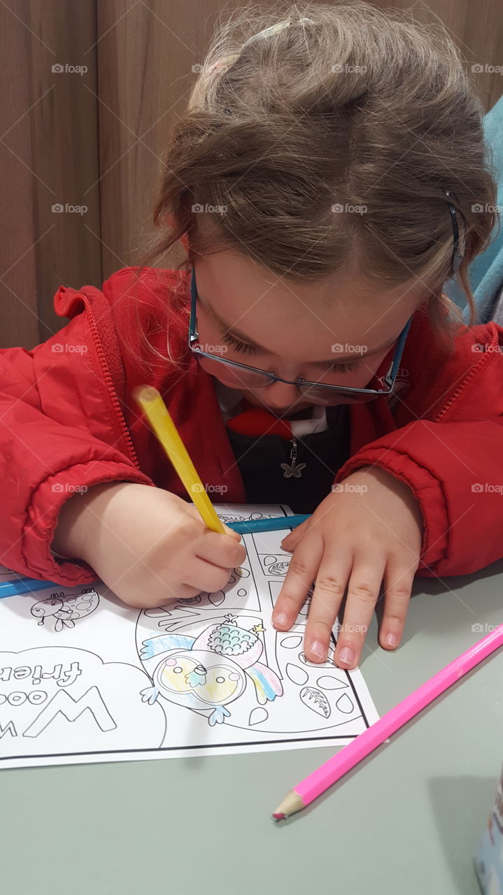 Four Year Old Girl Concentrating on Colouring In