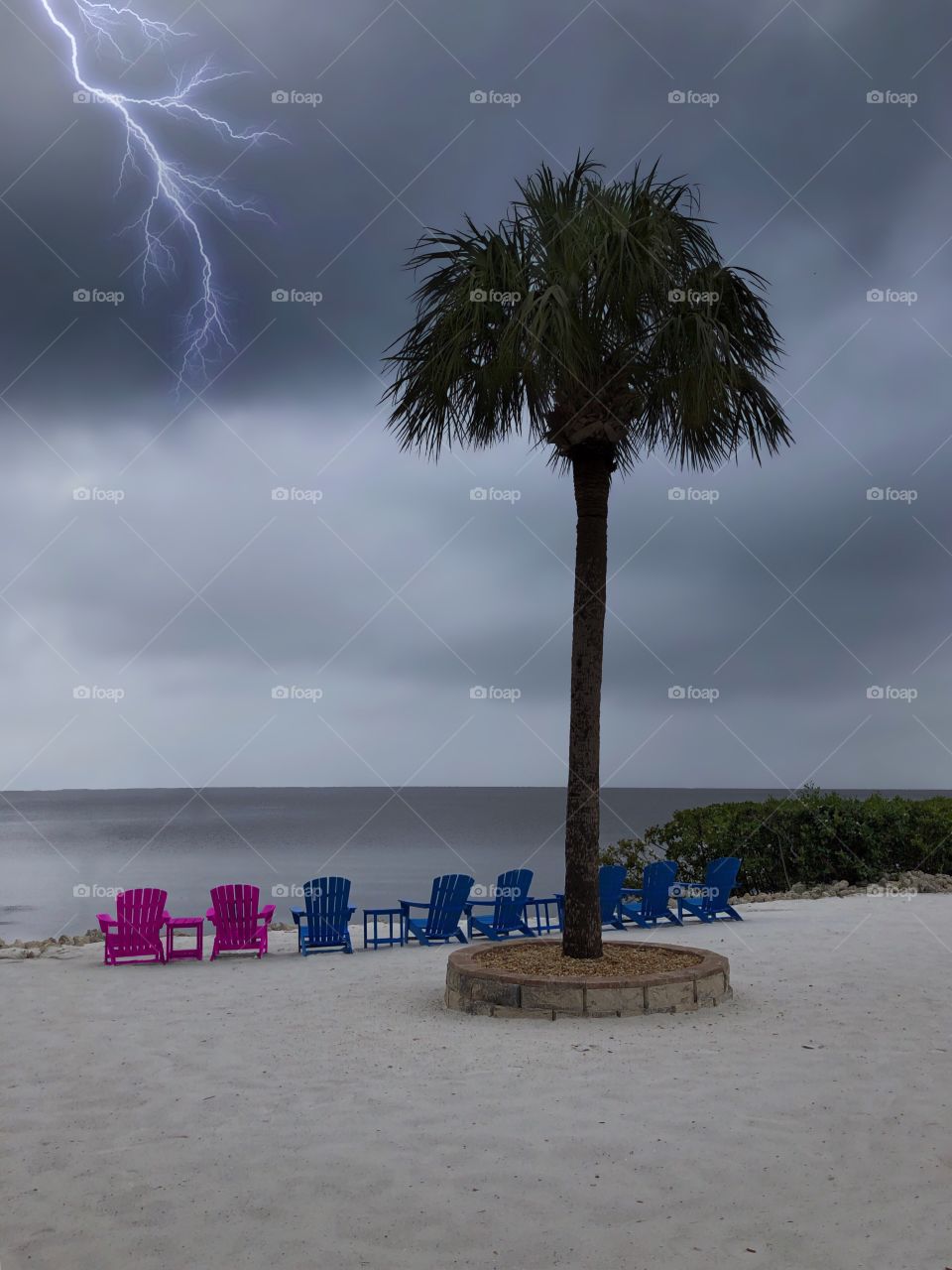 Intense lightning bolt on a stormy beach.