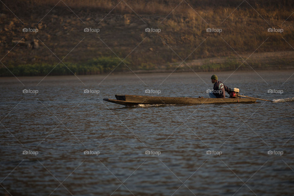 Man riding a boat in the river with mist