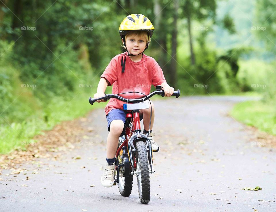 my nephew riding a bike with an serious cute face