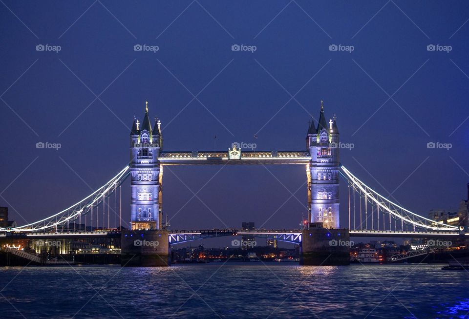 A view of London tower bridge from the river Thames in the blue hour.