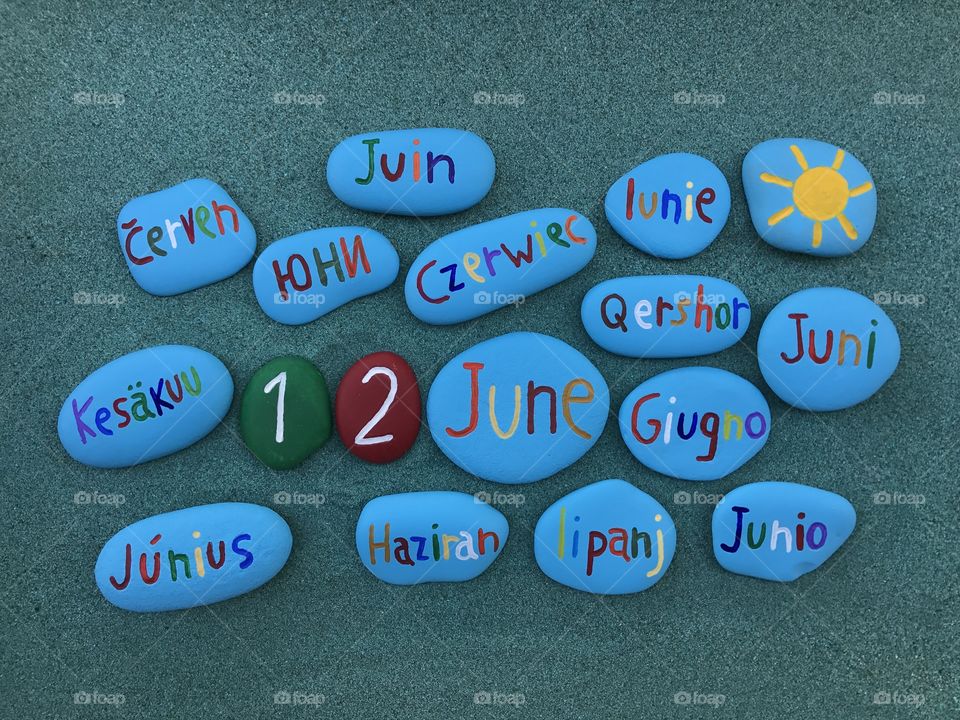 12 June, calendar date with colored stones over green sand