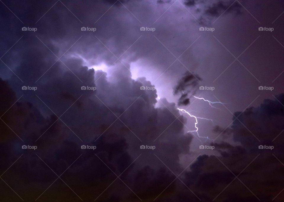 Low angle view of storm and lightning at night