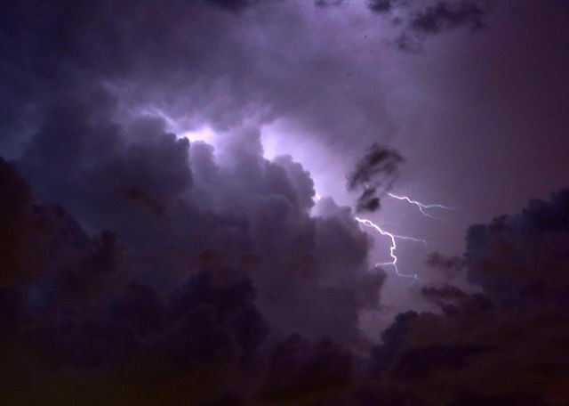 Low angle view of storm and lightning at night