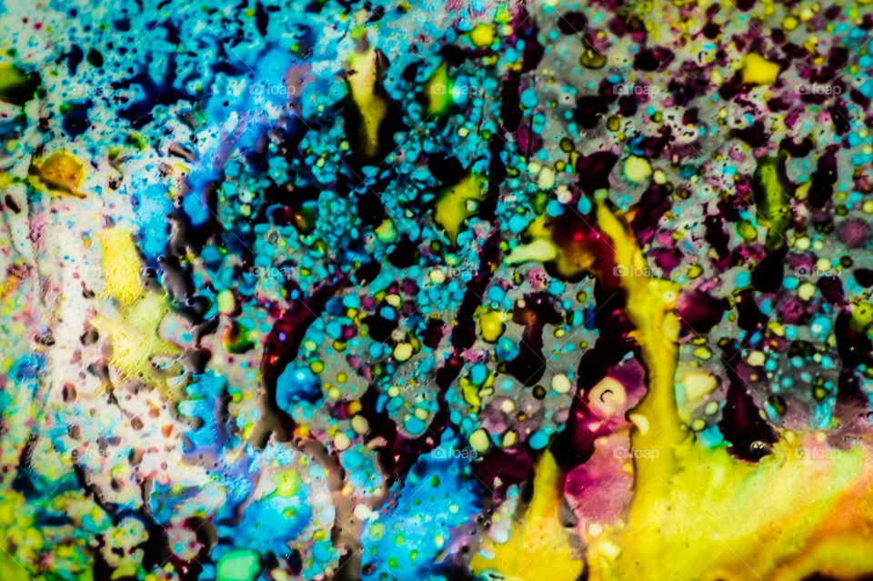 The ink to refill the printer cartridge was spilled onto the white washbasin and the paints blended into abstract drips and patterns