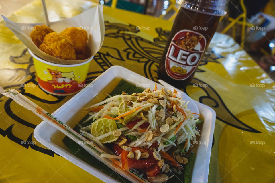 Green papaya salad, cheese balls, and Leo beer at a night market in Chiang Mai, Thailand 