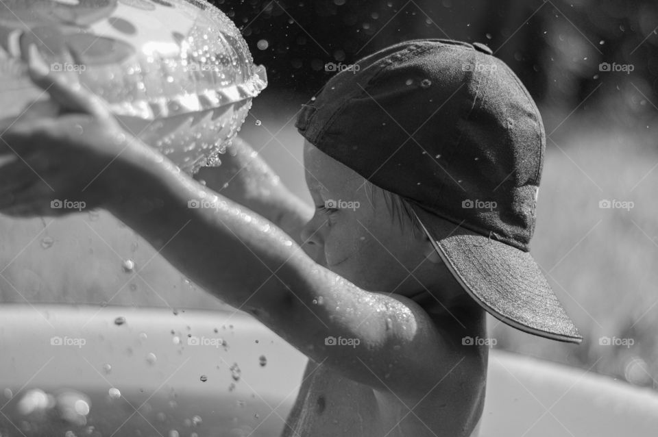 Todler boy playing in the pool. Black and White.