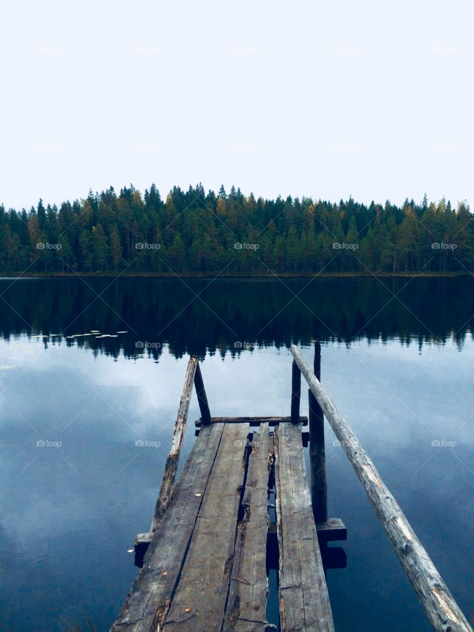 A wooden pier in a small lake in the wilderness in a Finnish national lake