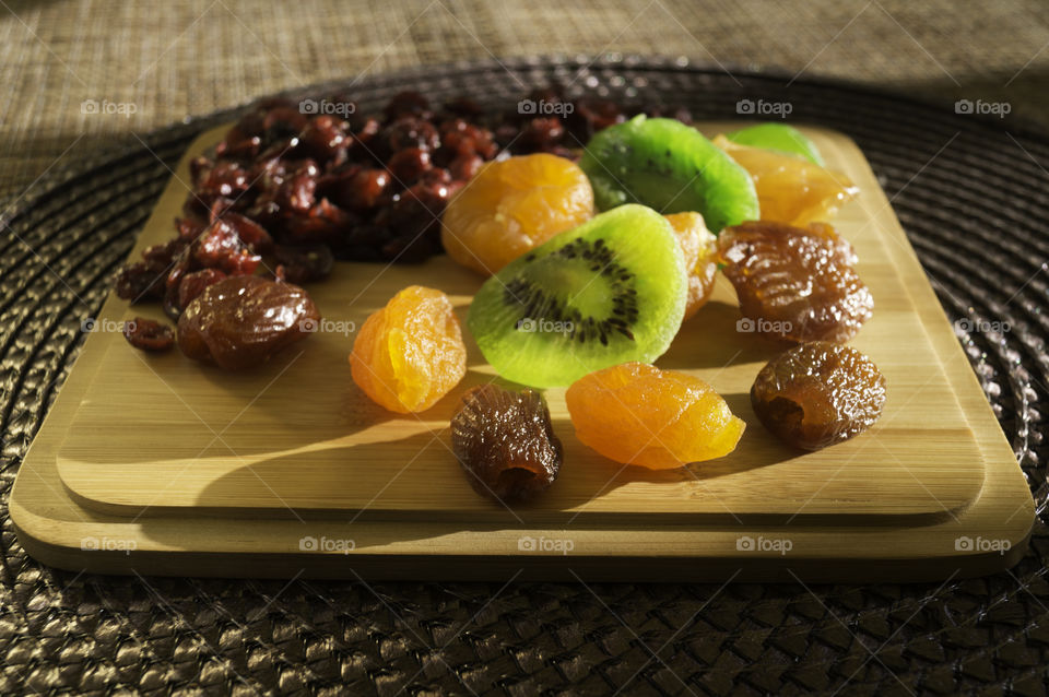dry fruits dry kiwis and cranberries in a wood table closeup