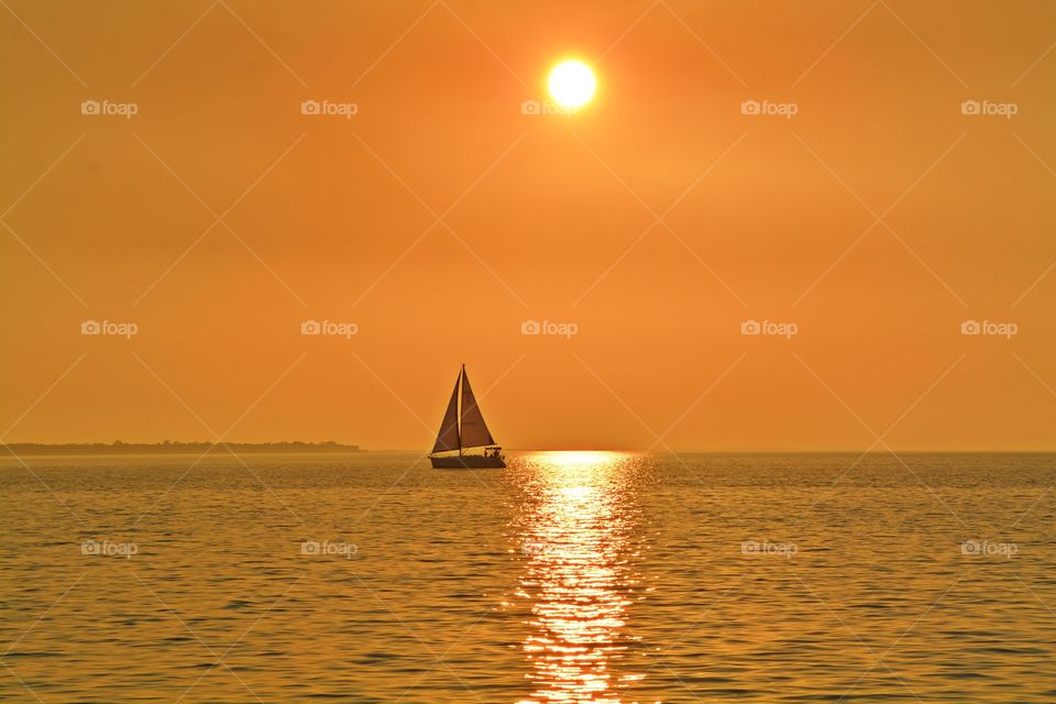 Sunrise, sunset and the moon - Destination unknown - Sailing in the magnificent golden sunset over the glistening bay water