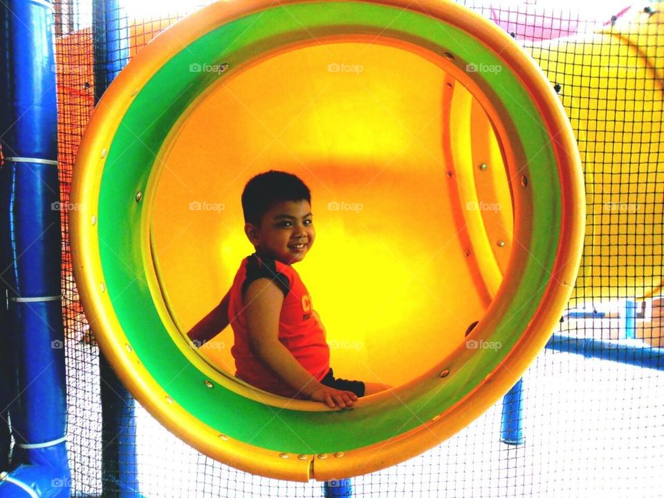 Little boy playing in a play pen