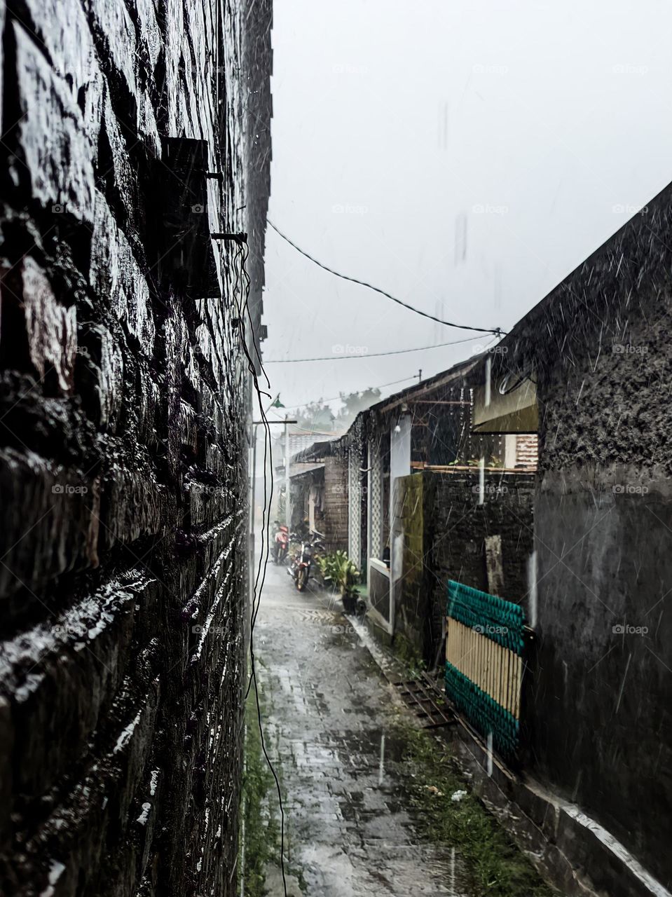 Portrait of a narrow alley between old buildings when it rains with quite high intensity