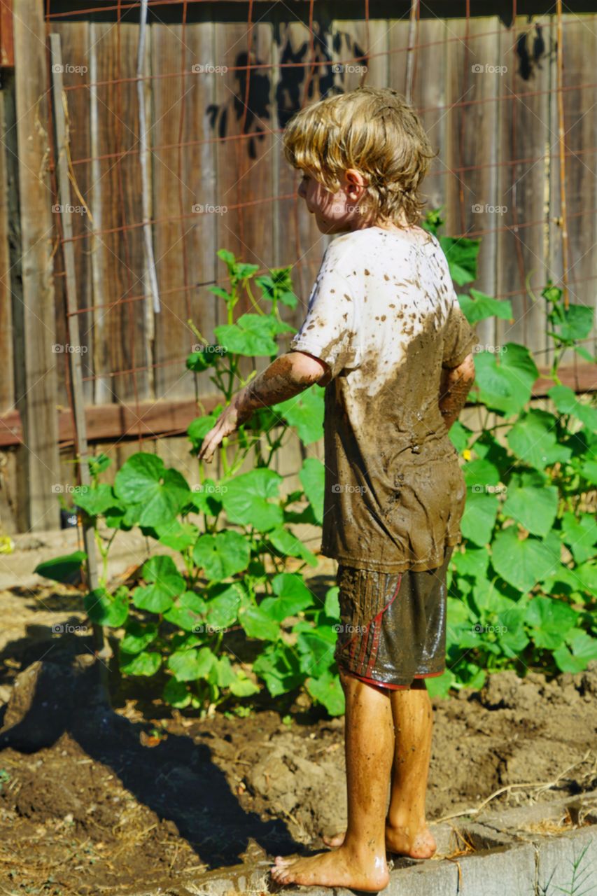 Child Playing With Mud In The Garden