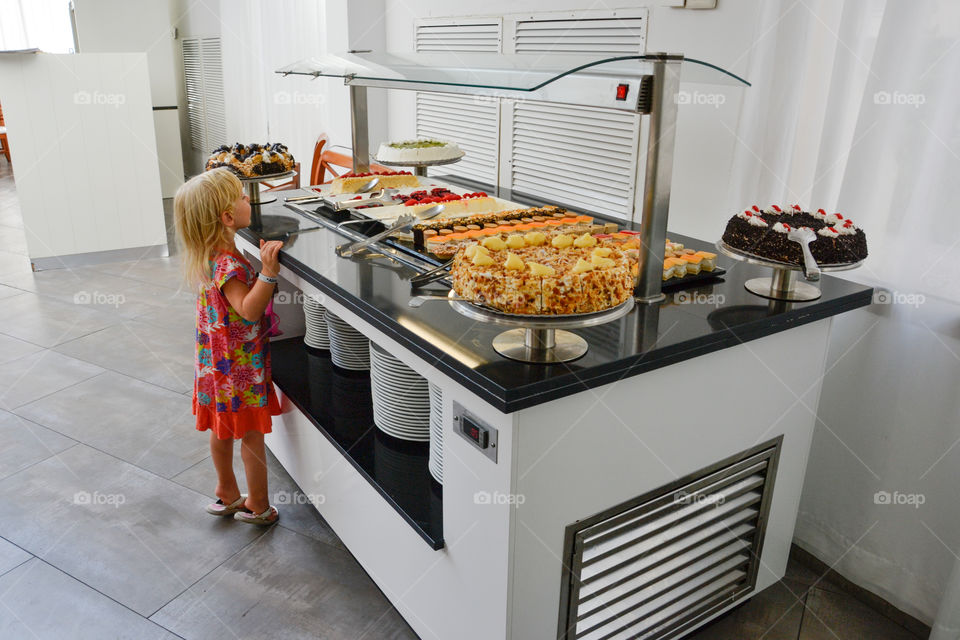 Little girl looking at the dessert buffet at hotel Alcudia Pins in Alcudia on Majorca.