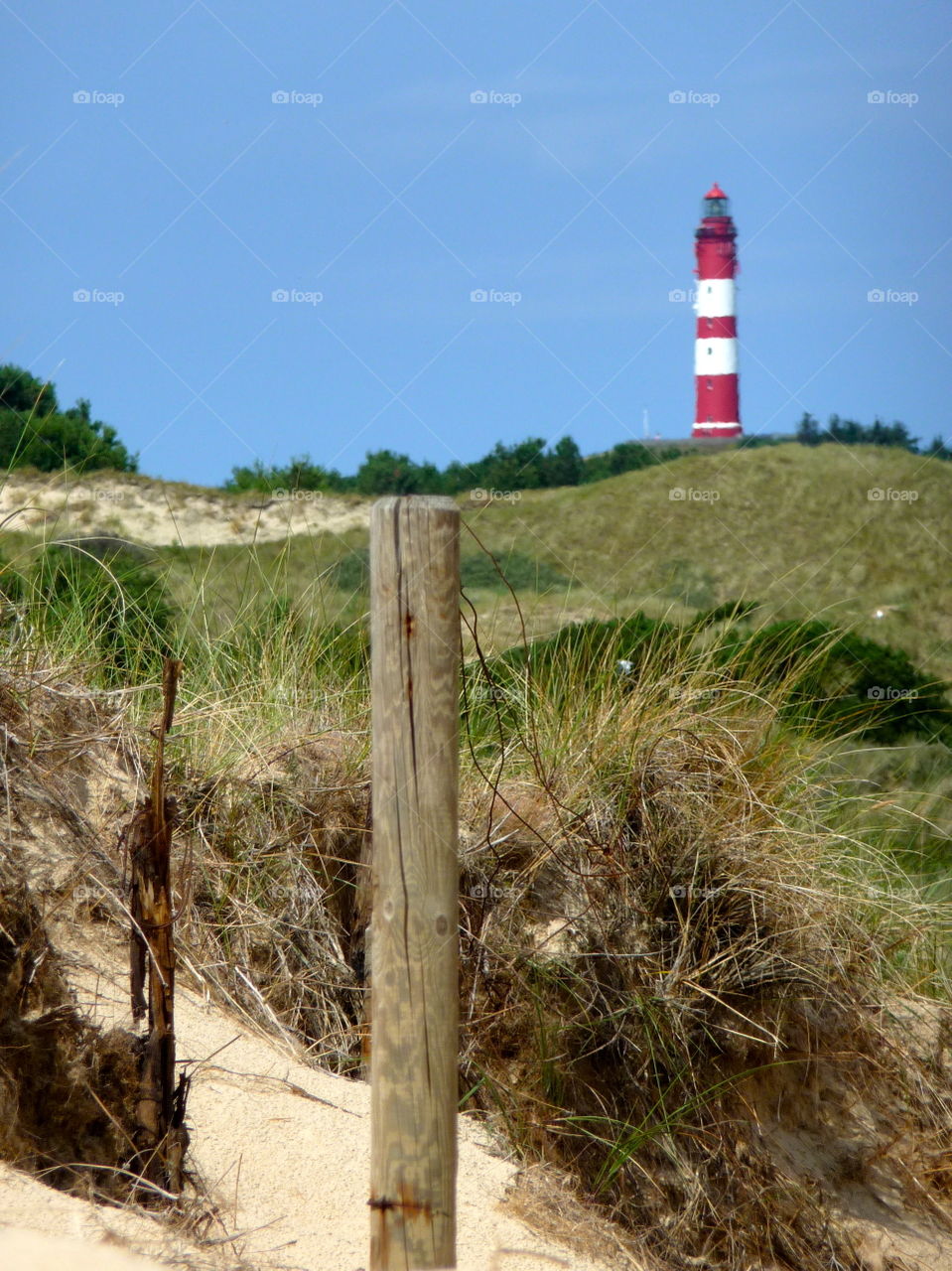 White and red striped Lighthouse at North Sea Island Amrum in Germany