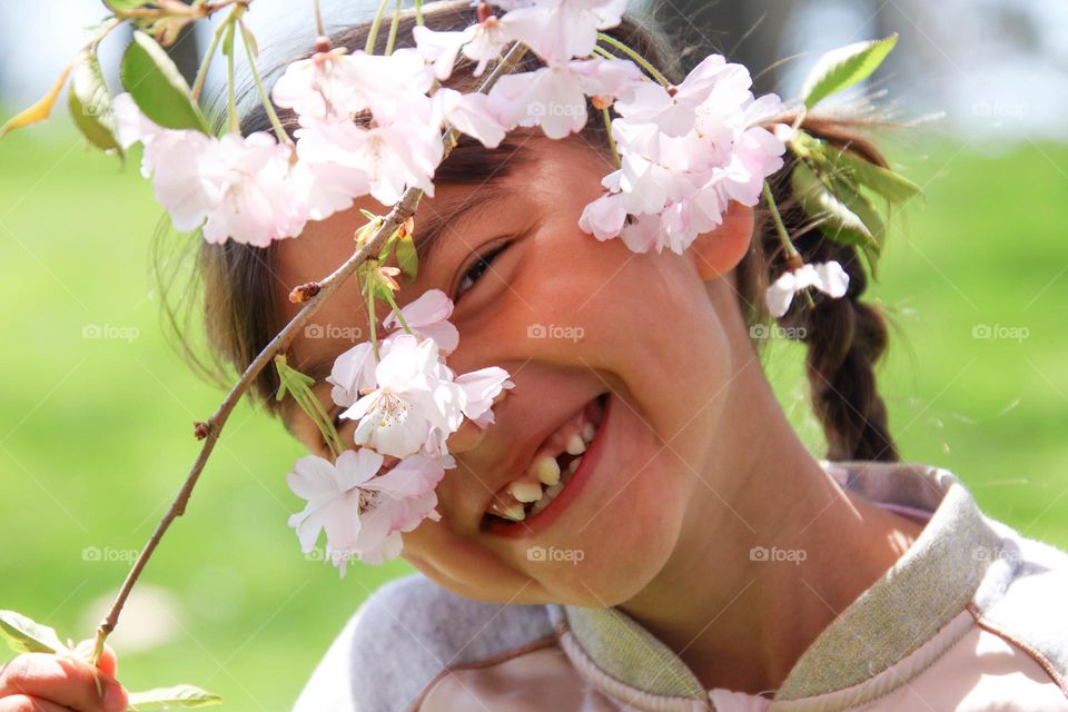 Cute girl with a branch of a cherry tree in bloom