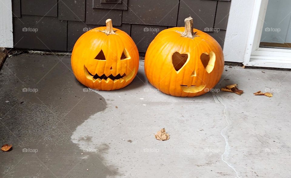 two bright orange carved pumpkins on a porch in Oregon Suburbs to celebrate Halloween in October