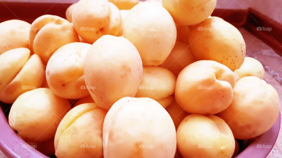Large yellowish beautiful apricots in a bowl