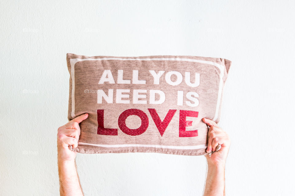 Man Hands Holding A Pillow With A Love Message Isolated In White Background
