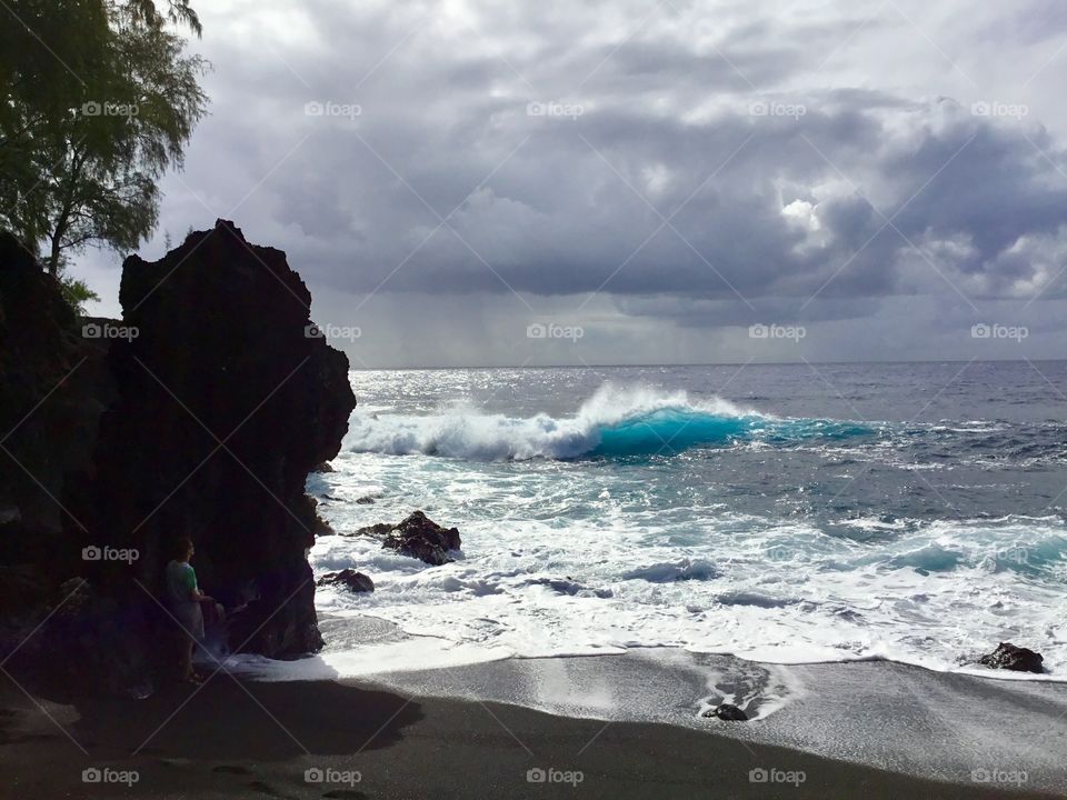 Wave coming to meet the black sand and lava rock