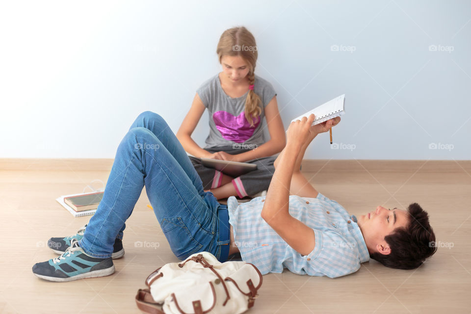 Girl and boy sitting on the floor in the classroom at school