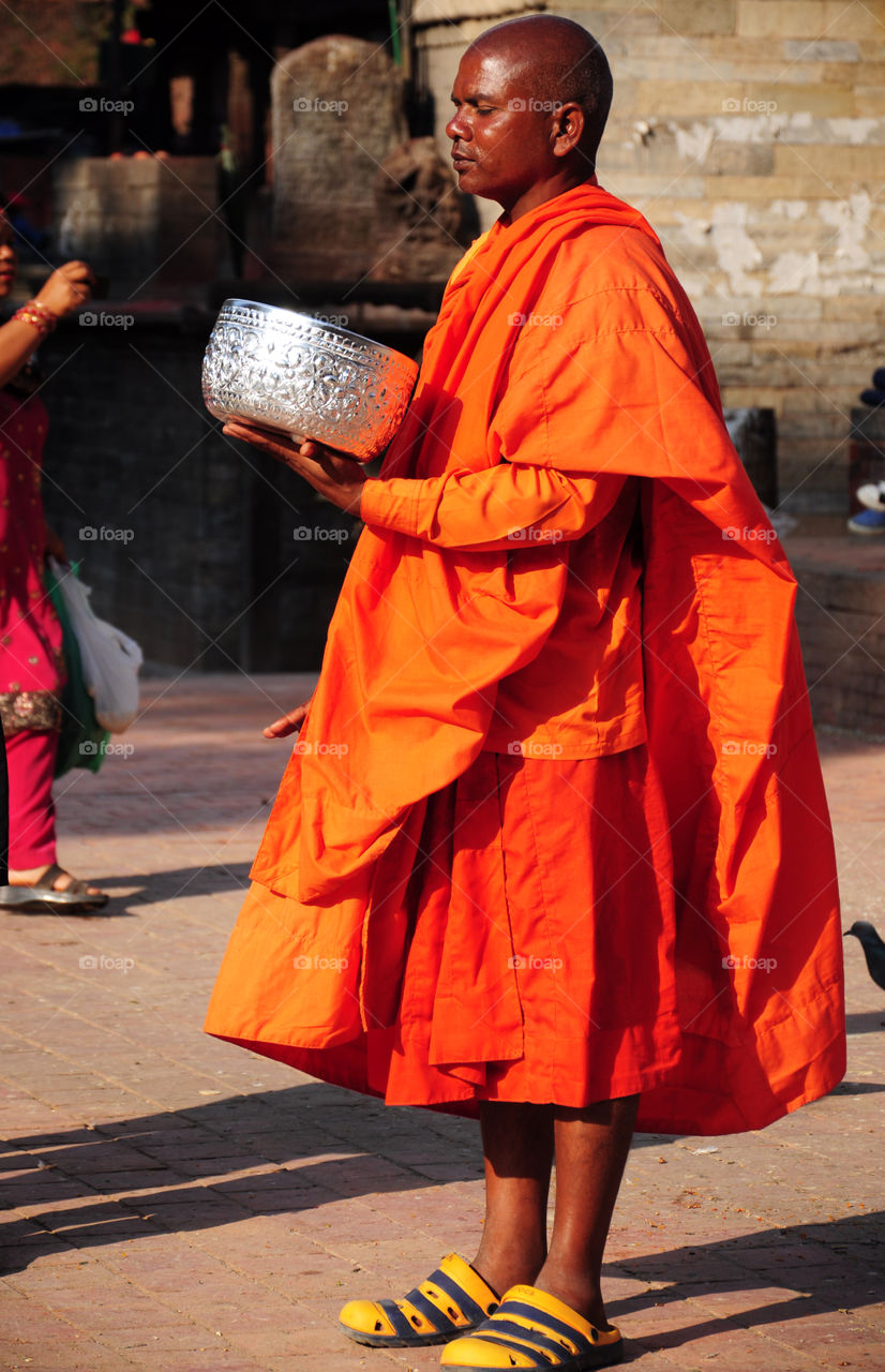 buddhist monk with singing bowl making rituals in the temple in kathmandu, nepal