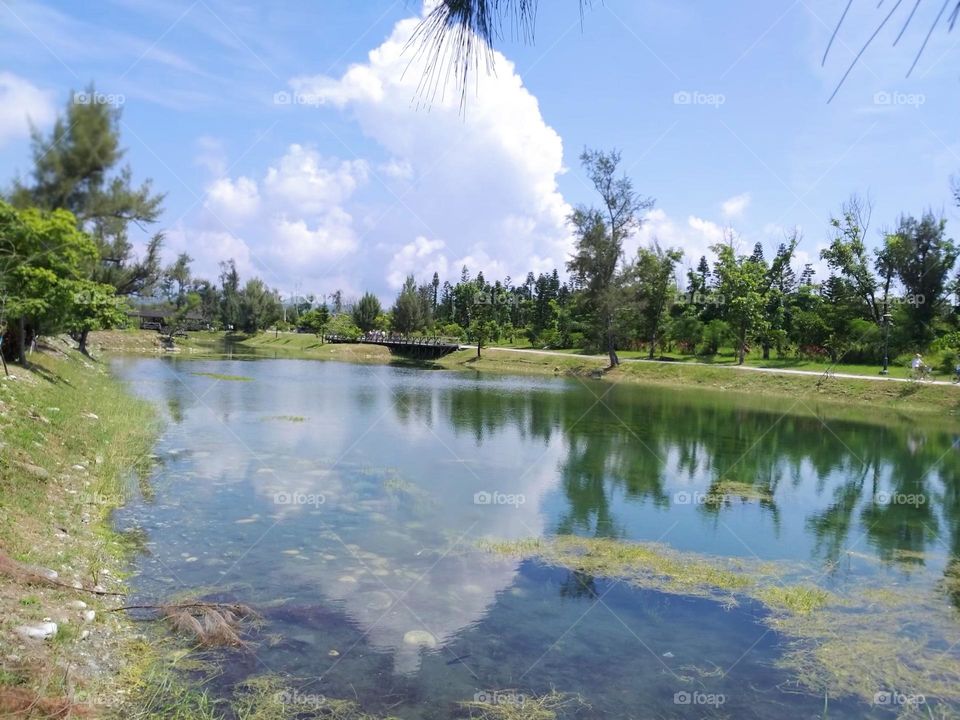 Blue sky, white clouds and lake water reflection