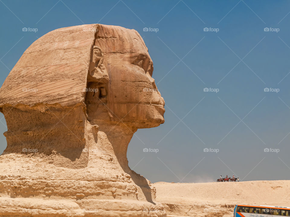 Riders on horses admiring Sphinx monument from distant hill.