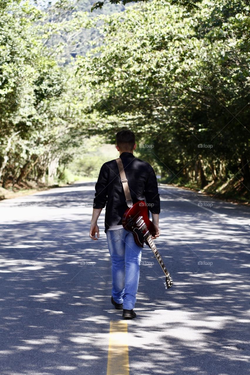 the boy with his guitar on the street