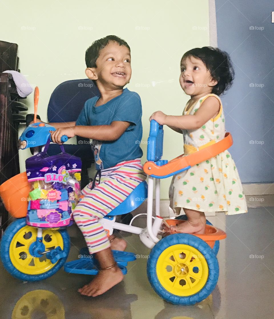 Brother and Sister enjoying tricycle riding 