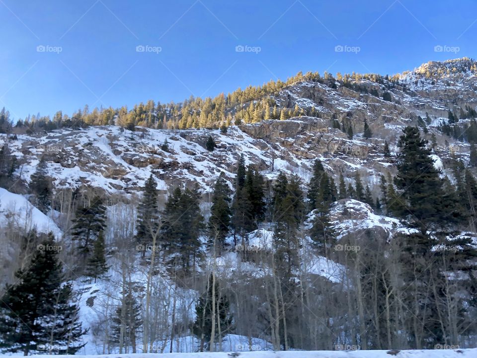 Rocky mountainside and snow on a clear day.