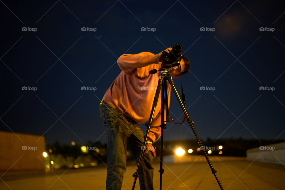 Man taking photograph with camera at night