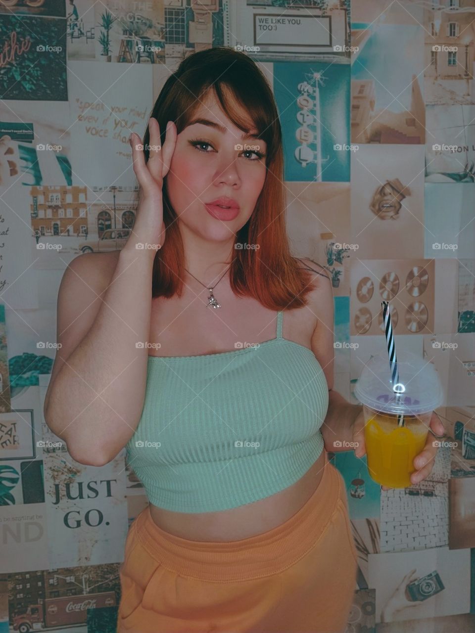 Beautiful woman with red hair and drinking orange juice