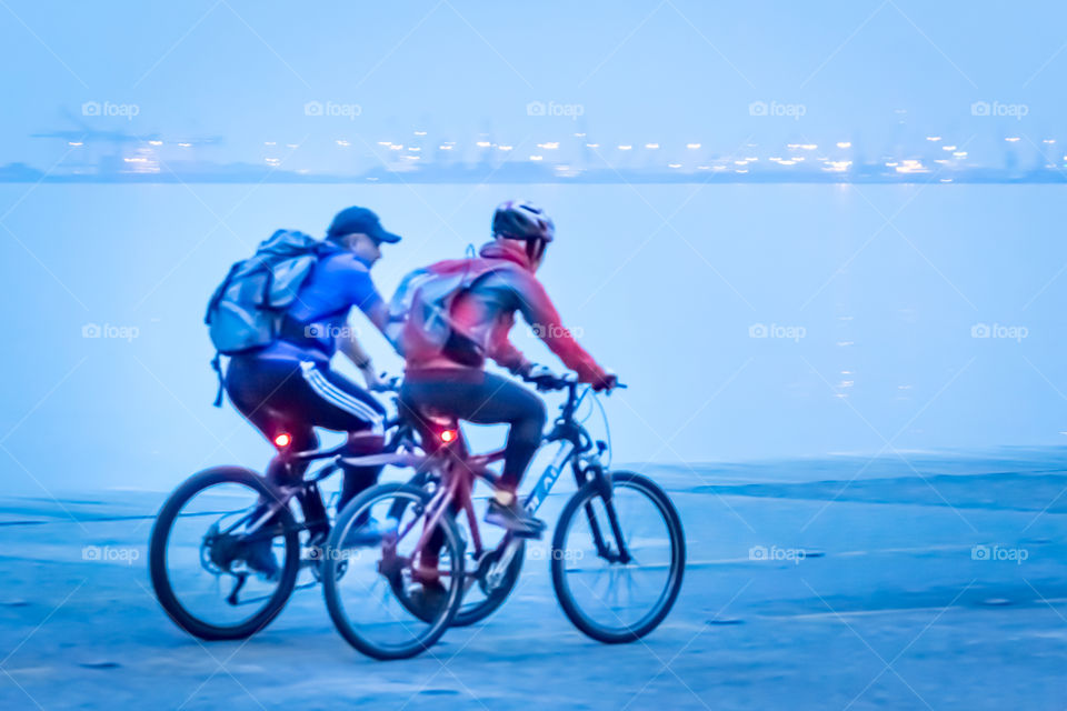 City Bikers With Backpacks At Blue Hour Night Time