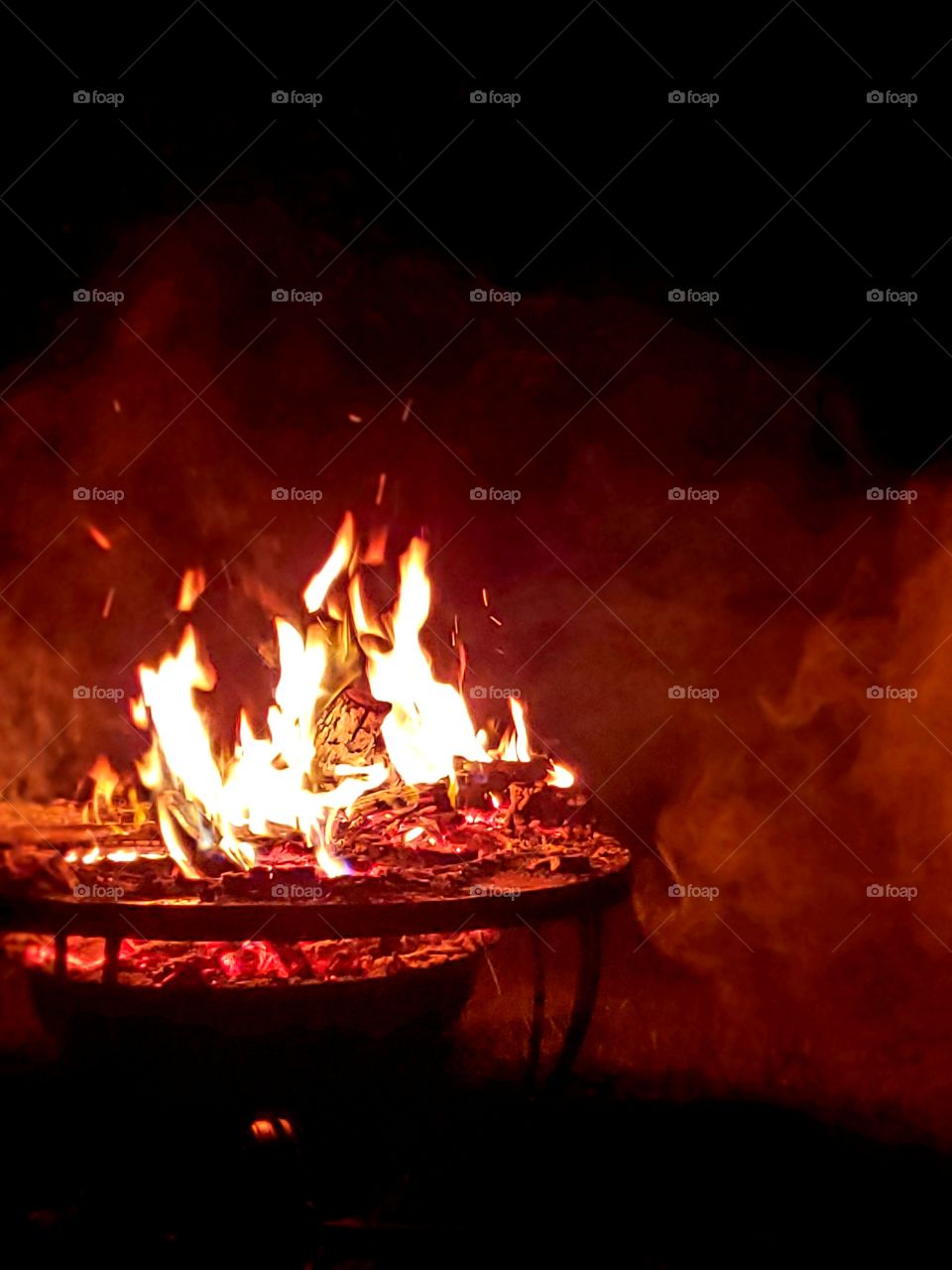 red smoke around a campfire at night