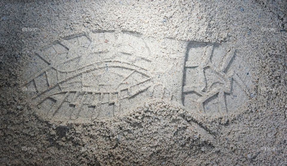 The soles of the feet of the shoes on the sand and moonlight
