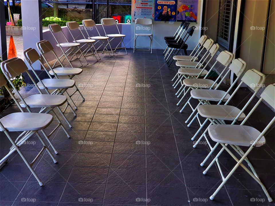 Chairs lined up in the waiting room of the office, chairs for costomers of gold buying and selling company, offices of state-owned company, chairs made of steel frames, clean white, dark floors
