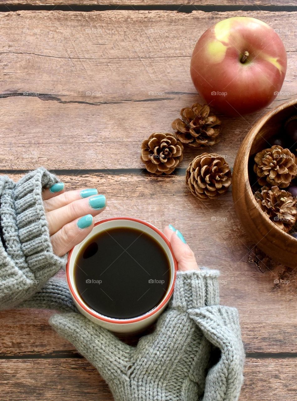 Turquoise nail polish on woman’s nails in an autumn setting 