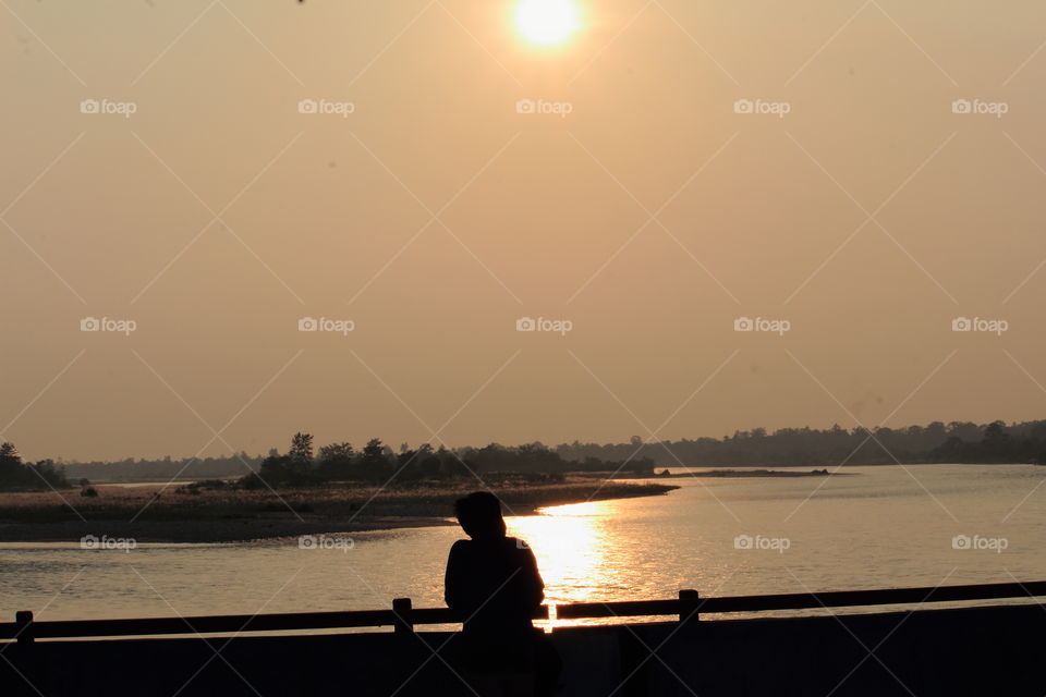 man standing alone , thinking alone in beautiful view of river at moon night