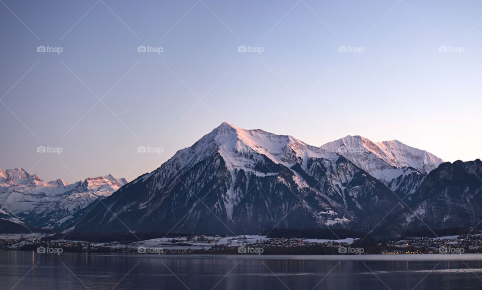 Mountain (niesen) and lake thun during twilight.