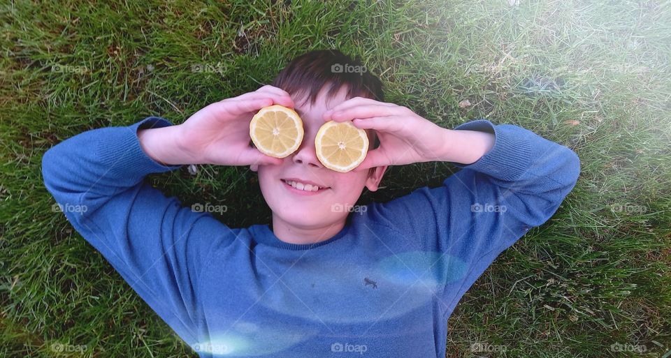 smiling boy is lying on the grass